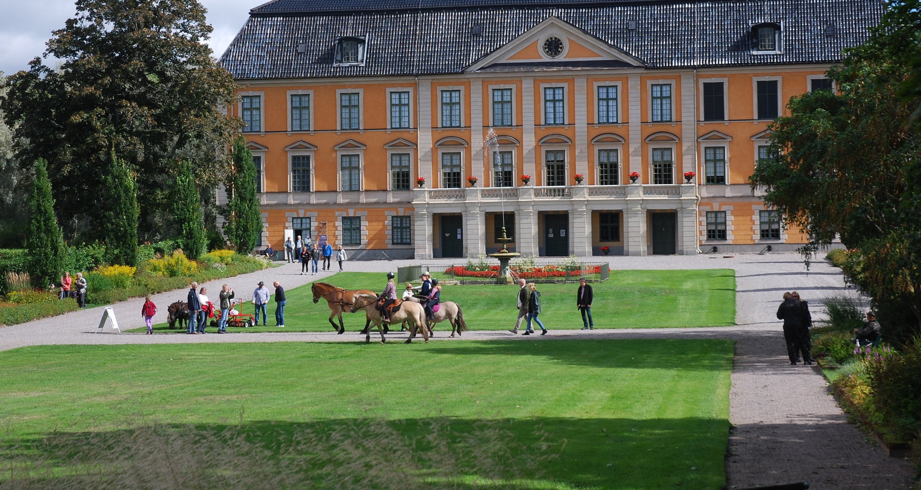 Nynäs slottspark i full grönska. I bakgrunden syns den gula slottsbyggnaden.