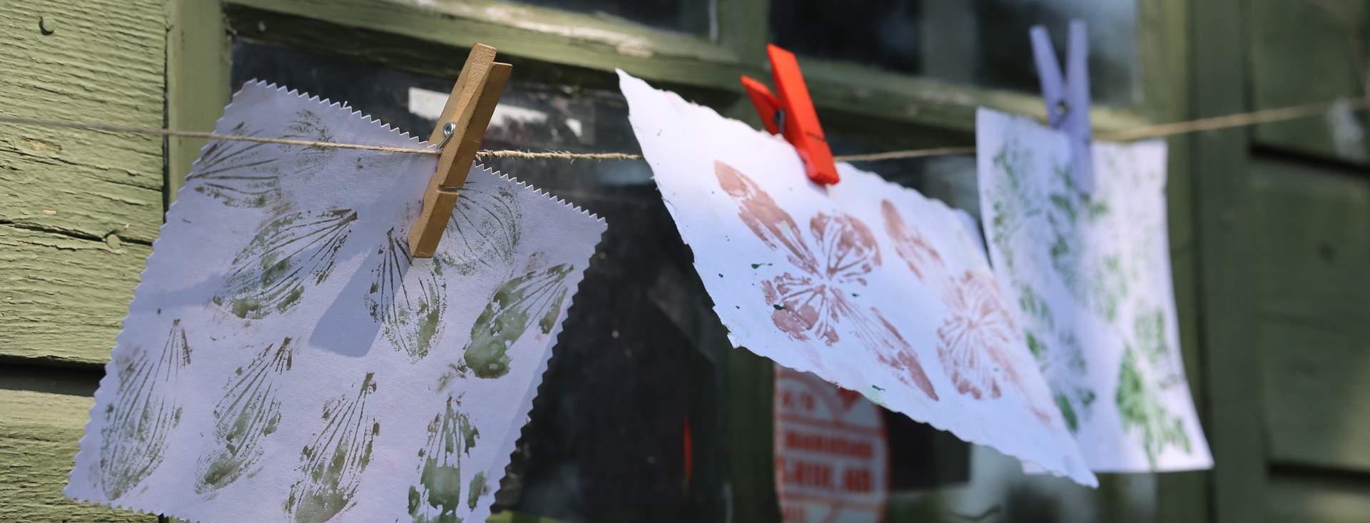 Papper med målade blommor hänger på tork och blåser i vinden.